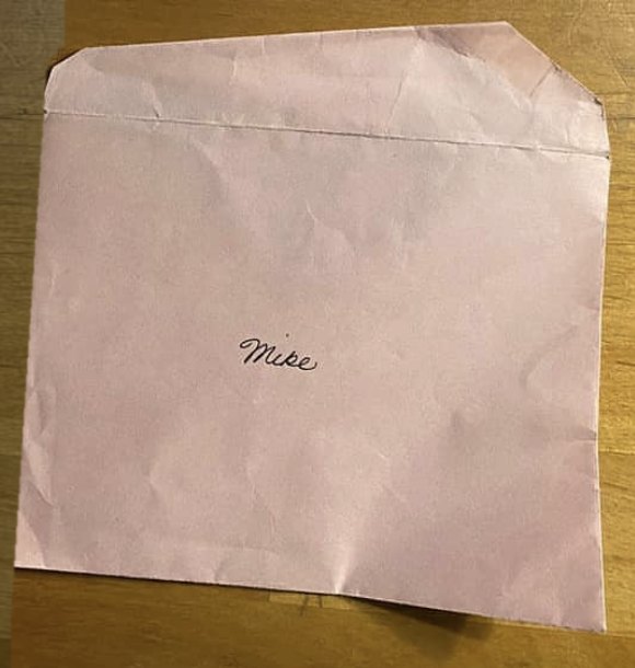 The pink envelope, addressed Mike in her hand